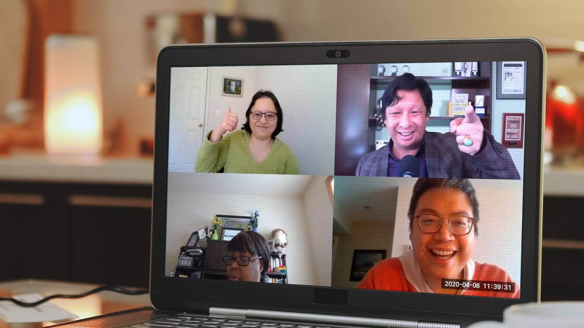 Four colleagues on a laptop screen giving a thumbs up during a virtual Name That Tune game — Engagement Unlimited virtual and online corporate events, Vancouver