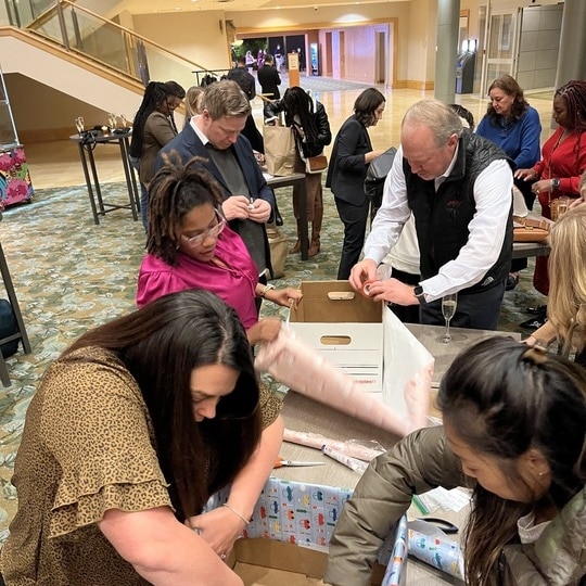 A team builds Birthday Boxes together at their table