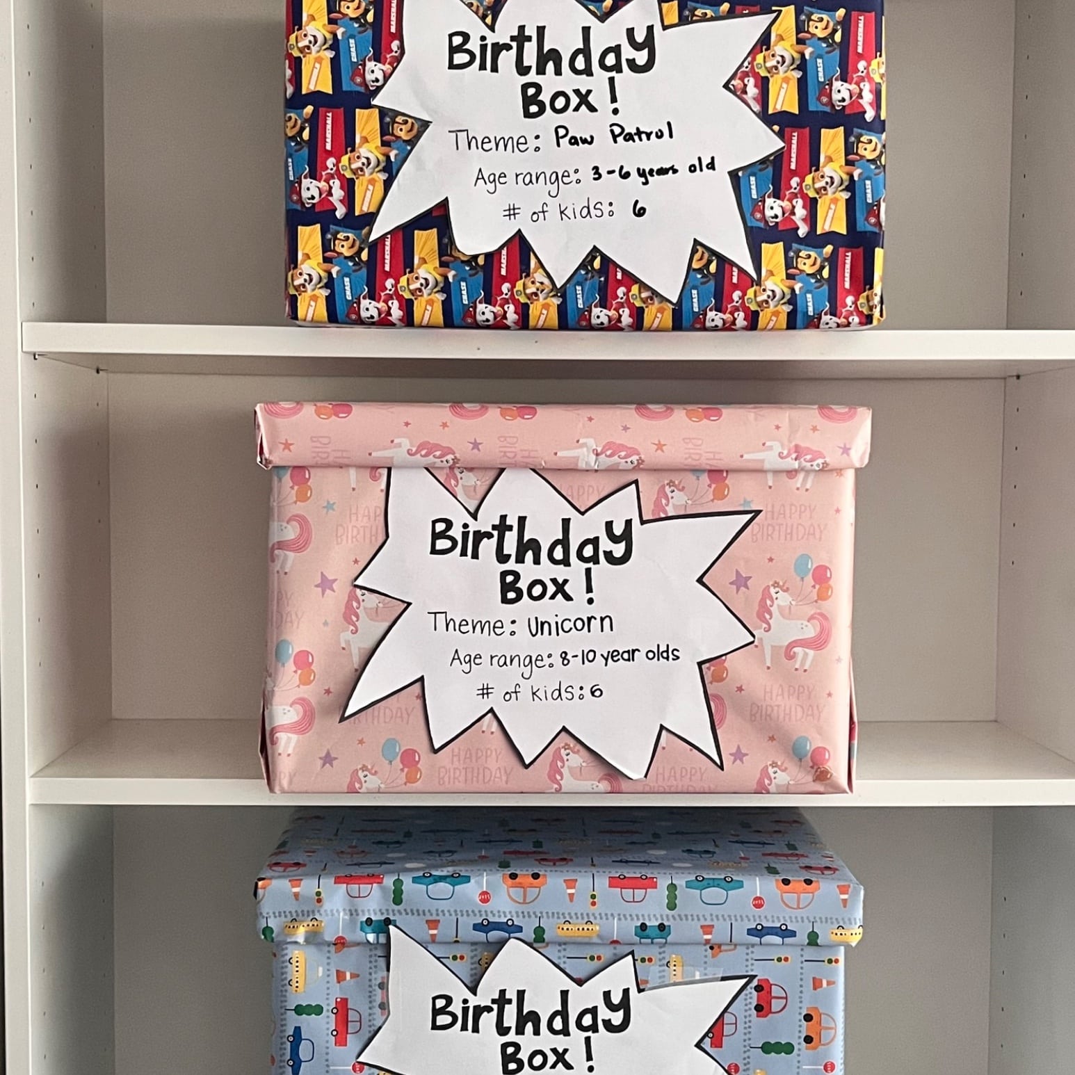 Three completed Birthday Boxes stacked and ready to give