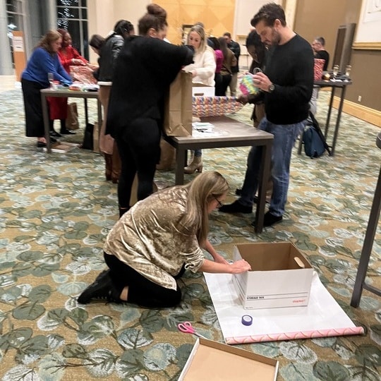 Employees building Birthday Boxes on the floor