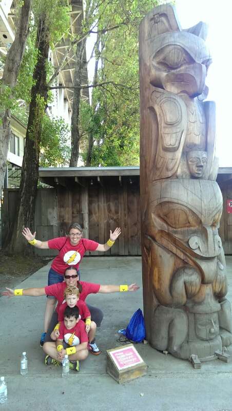 A family poses at the Granville Island totem pole stop