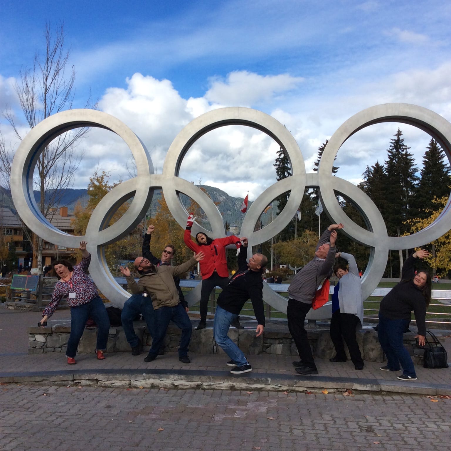A team poses at the Olympic Rings landmark stop