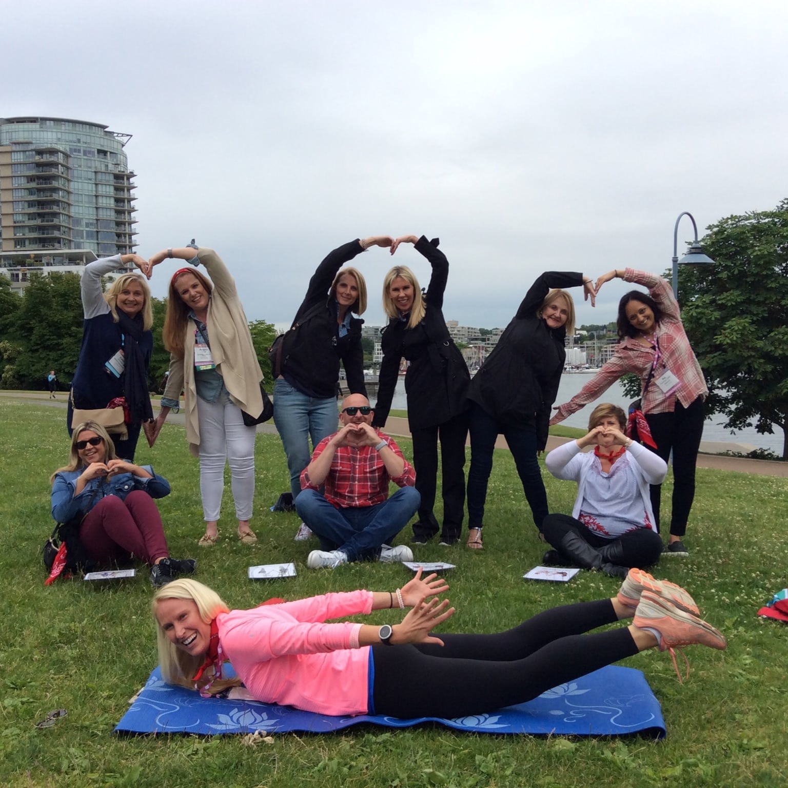 A team strikes a yoga pose along the False Creek seawall