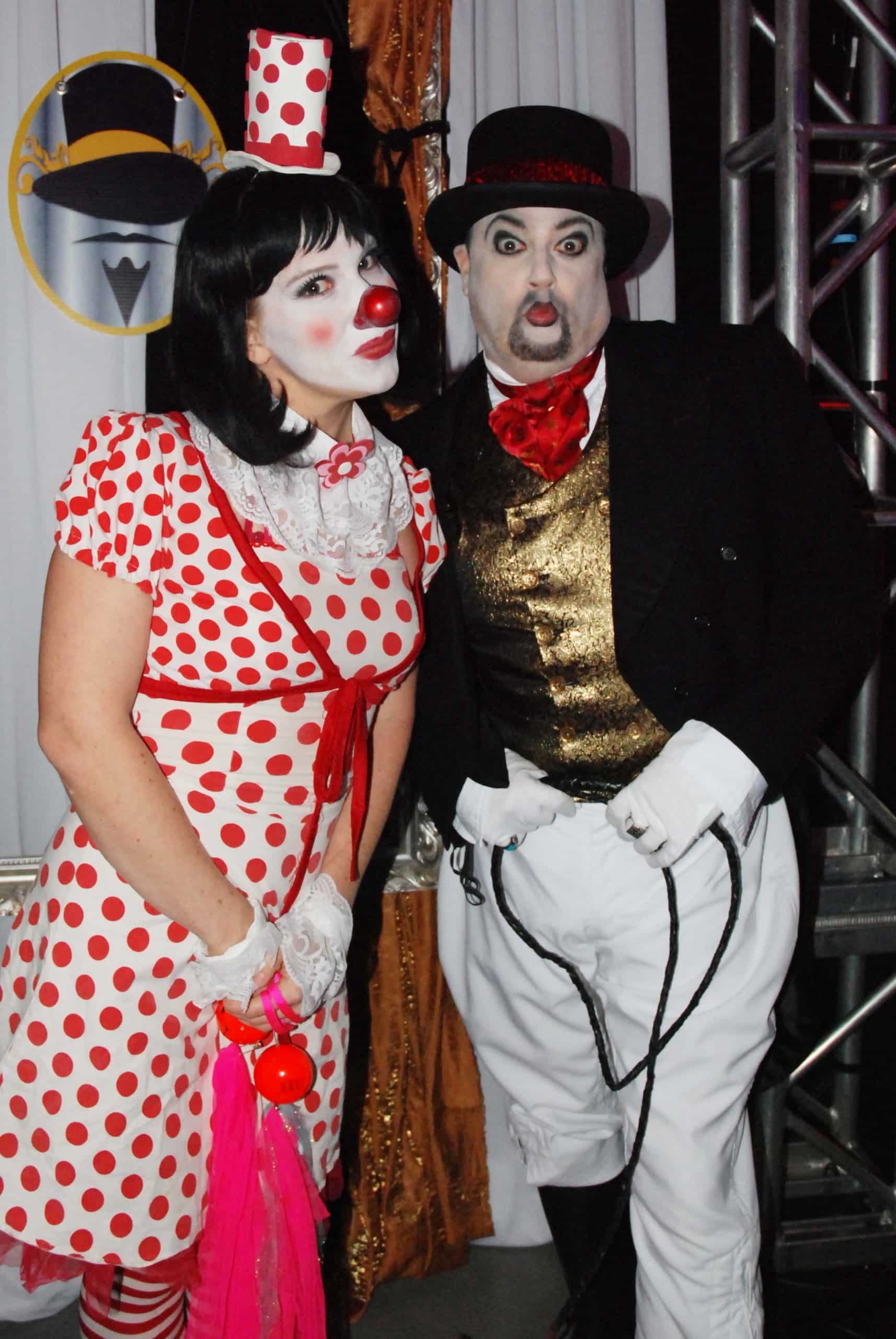 A vaudeville-style clown and ringmaster duo pose in circus costume ahead of a themed show