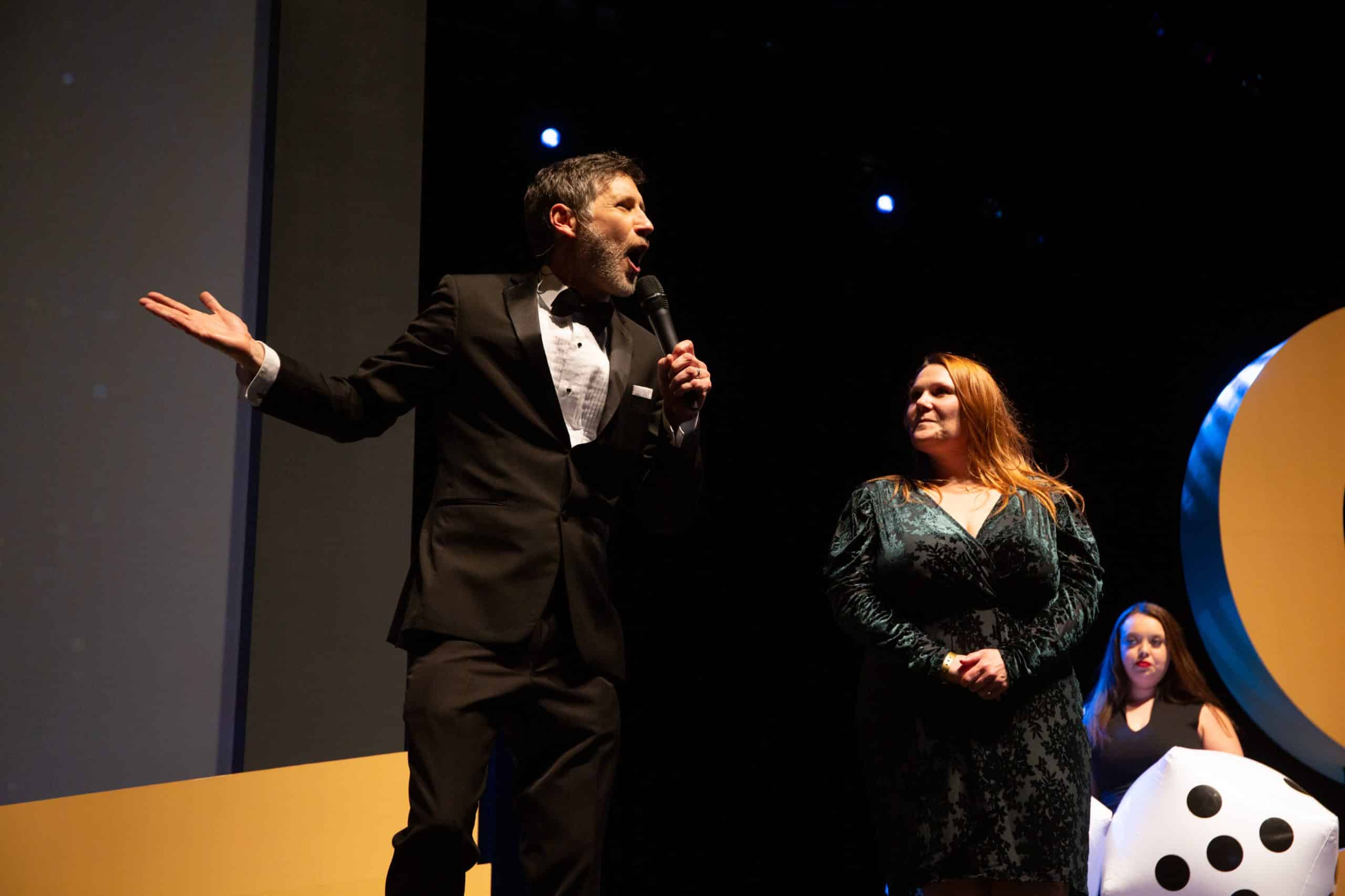 Roger brings an audience member on stage at a Coast Capital event