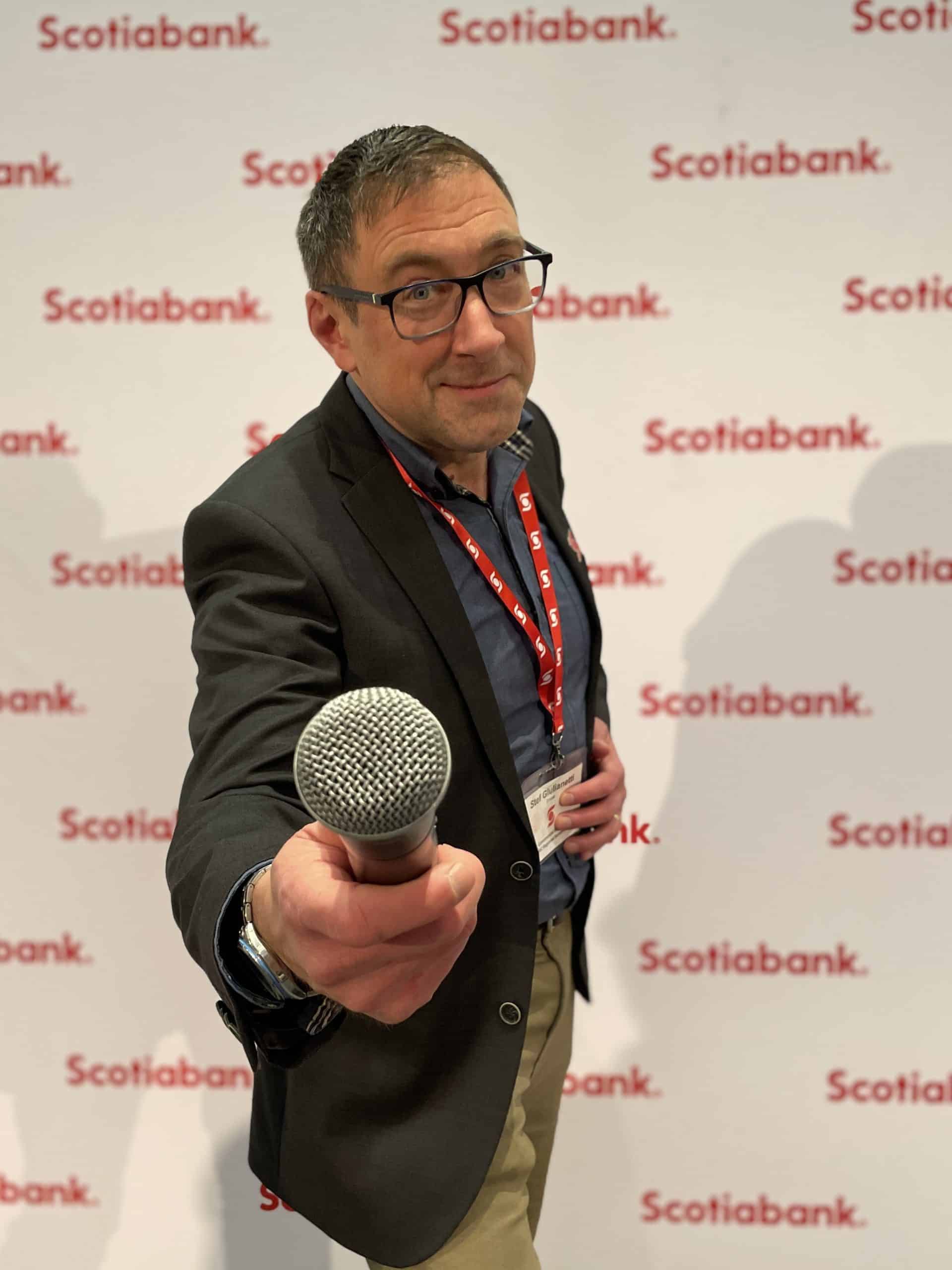 Emcee Stefano holds out the mic for an interview at a Scotiabank corporate event