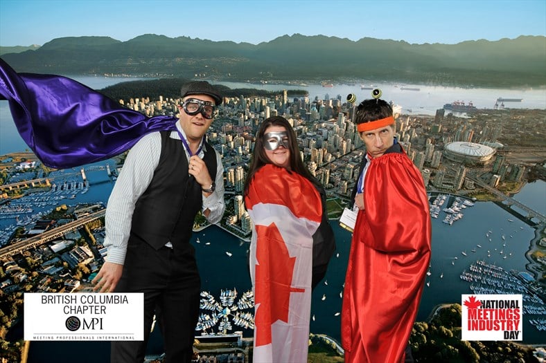 A group poses for a custom backdrop in the Green Screen Photo Studio
