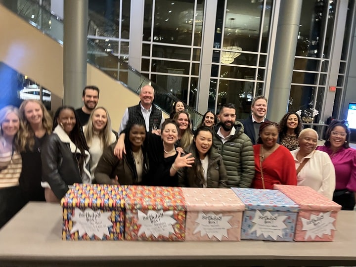 A smiling group stands behind their finished Birthday Boxes