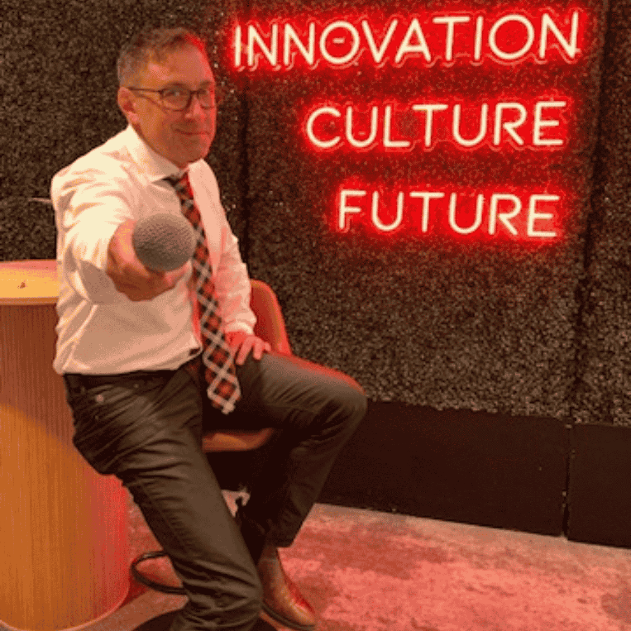 Stefano leads a conference as emcee against an innovation-themed backdrop