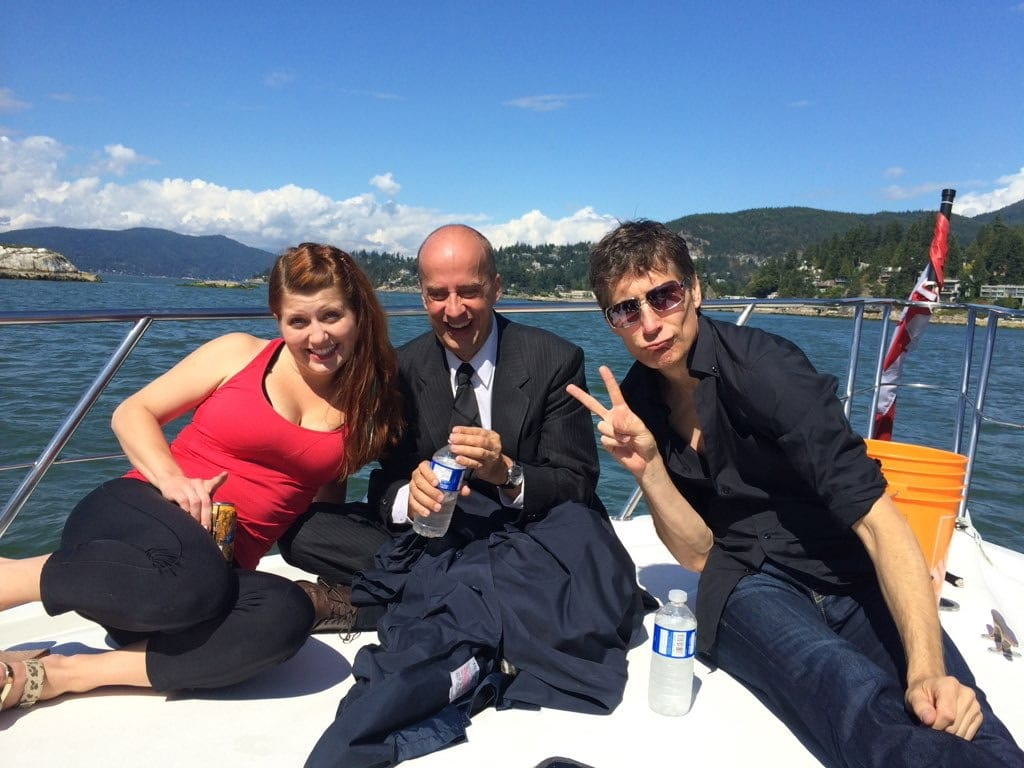 The cast relaxes with guests on deck after the reveal, still in character wardrobe.