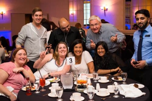 A table team celebrating during Pop Trivia at a corporate event