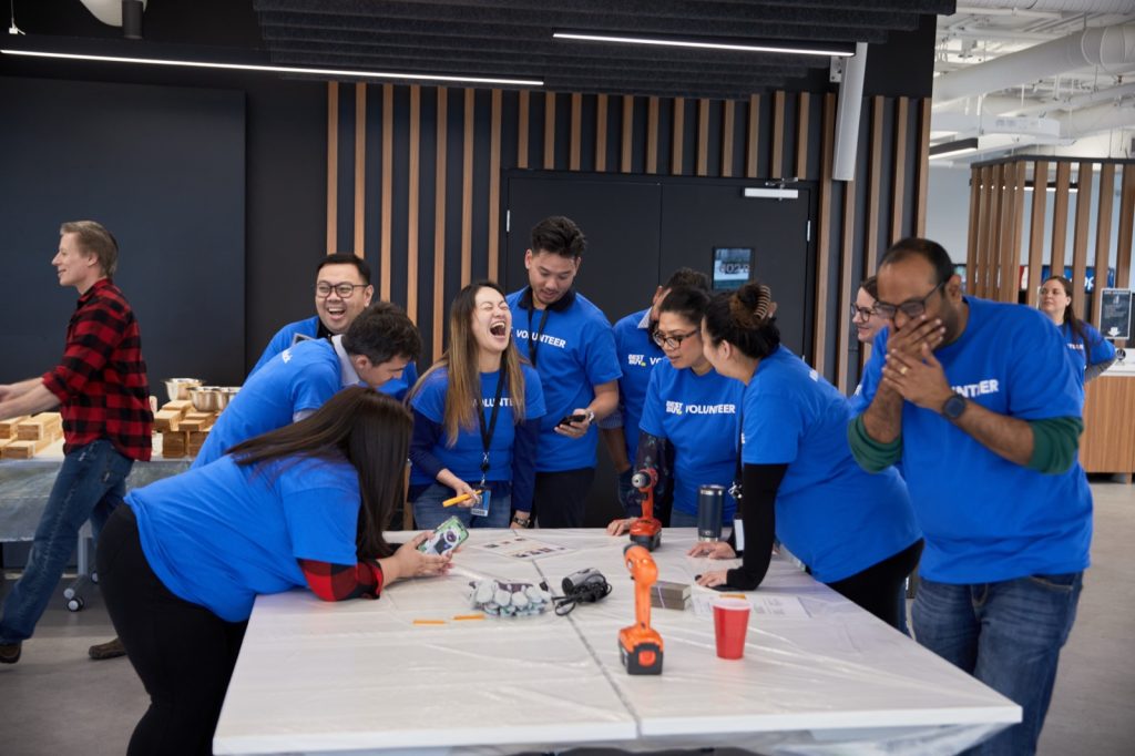 Laughter breaks out mid-build as a team races to finish their MudPie Kitchen
